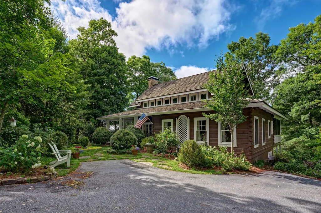 Wood-sided cottage with garden beds along the walkway